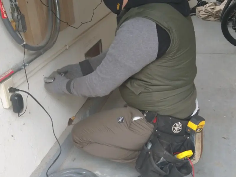 Electrician performing outlet wiring in a Wade Hampton garage